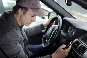 Man at wheel using cell mobile phone while driving car